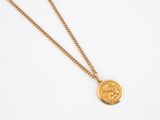 a gold coin necklace with a lion on a chain