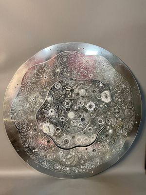 une plaque métallique ornée d'un motif, à côté d'une bouteille de vin