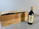 une bouteille de vin dans un coffret en bois à côté d'une bouteille de vin