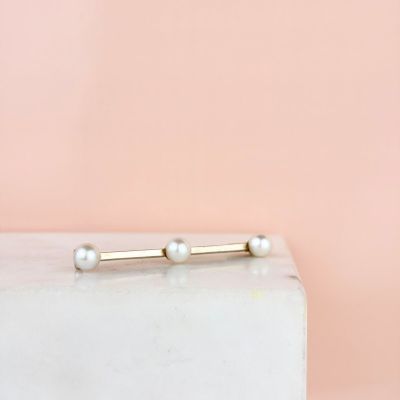 a white marble block with a gold bar and pearls on it
