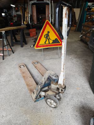a fork lifter with a sign on it in a garage
