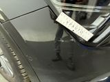 a man standing next to a car with a sticker on it