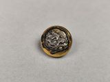 une pièce d'or et d'argent posée sur une surface blanche