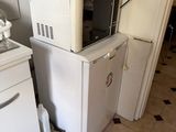a microwave sitting on top of a refrigerator in a kitchen