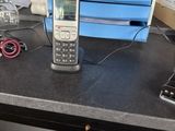un téléphone portable posé sur un bureau, à côté d'une pile de cartons