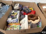 une boîte en carton remplie de jouets et de jeux, posée par terre