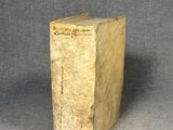 un vieux livre posé sur une table à côté d'un fond gris