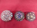 three different types of glass beads on a red surface
