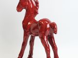 a red statue of a horse on a white background