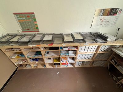 a desk with a lot of files and a laptop on it
