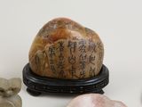 a rock that has writing on it next to other rocks