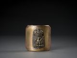une vieille coupe en laiton ornée d'un blason