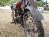 a motorcycle that is parked in the grass under a shelter