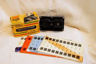 une photo en noir et blanc représentant un vieil appareil photo et une boîte de cassettes