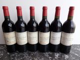 six bouteilles de vin rouge sont alignées