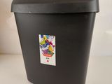 une poubelle noire sur laquelle est collé un autocollant