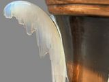 a vase with wings on it that is sitting on a table