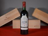 a bottle of wine sitting on a table next to two wooden boxes