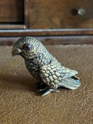a small figurine of a parrot sitting on a table
