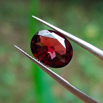 un gros plan sur un diamant rouge tenu par deux tweets