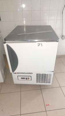 an image of a small white refrigerator in a bathroom