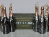three bottles of champagne are wrapped in plastic and sitting next to a box