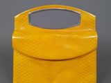 a yellow purse with a mirror on top of it