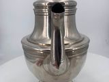 a silver tea pot sitting on a white table