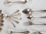 a lot of silver spoons and forks on a table