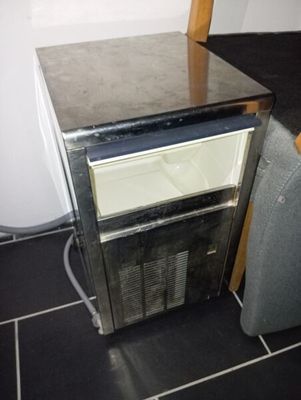 une photo d'un petit réfrigérateur dans un coin d'une pièce