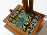 a small wooden stand with a tile design on it