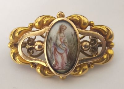 une image représentant une femme tenant un enfant dans une broche en or