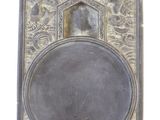 une vieille assiette en argent sur laquelle est représentée une femme