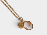 a gold necklace with a shell and a coin on it