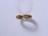 une image représentant une bague en diamant et en or posée sur une surface blanche