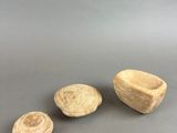 a group of three small rocks sitting on top of a gray surface