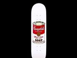 un skateboard sur lequel est posée une boîte de soupe, sur fond noir