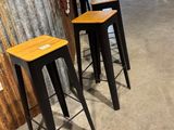 quatre tabourets placés devant un bar dans une pièce