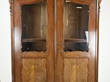un meuble en bois avec des portes en verre dans une pièce