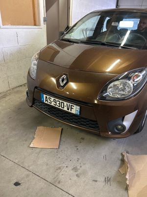 une voiture marron garée dans un garage, à côté d'un carton