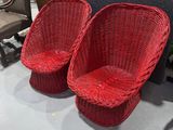 pair of red wicker chairs on display at a furniture store