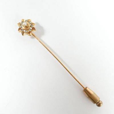 une image représentant une broche en or surmontée d'une fleur