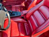 une photo d'une voiture en cuir rouge avec un volant