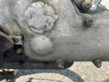 un gros plan d'un moteur de moto auquel est fixée une chaîne