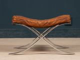 an image of a brown leather bench sitting on top of a cement floor
