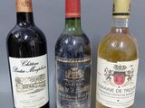 trois bouteilles de vin sont alignées sur une surface grise