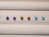 cinq pierres précieuses de couleurs différentes sont disposées en ligne sur une surface blanche