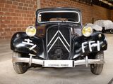 an old car parked in a garage with other cars in the background