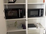 a microwave and a microwave oven in the corner of a cabinet