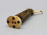 an old wooden pipe with black dots on it sitting on top of a table